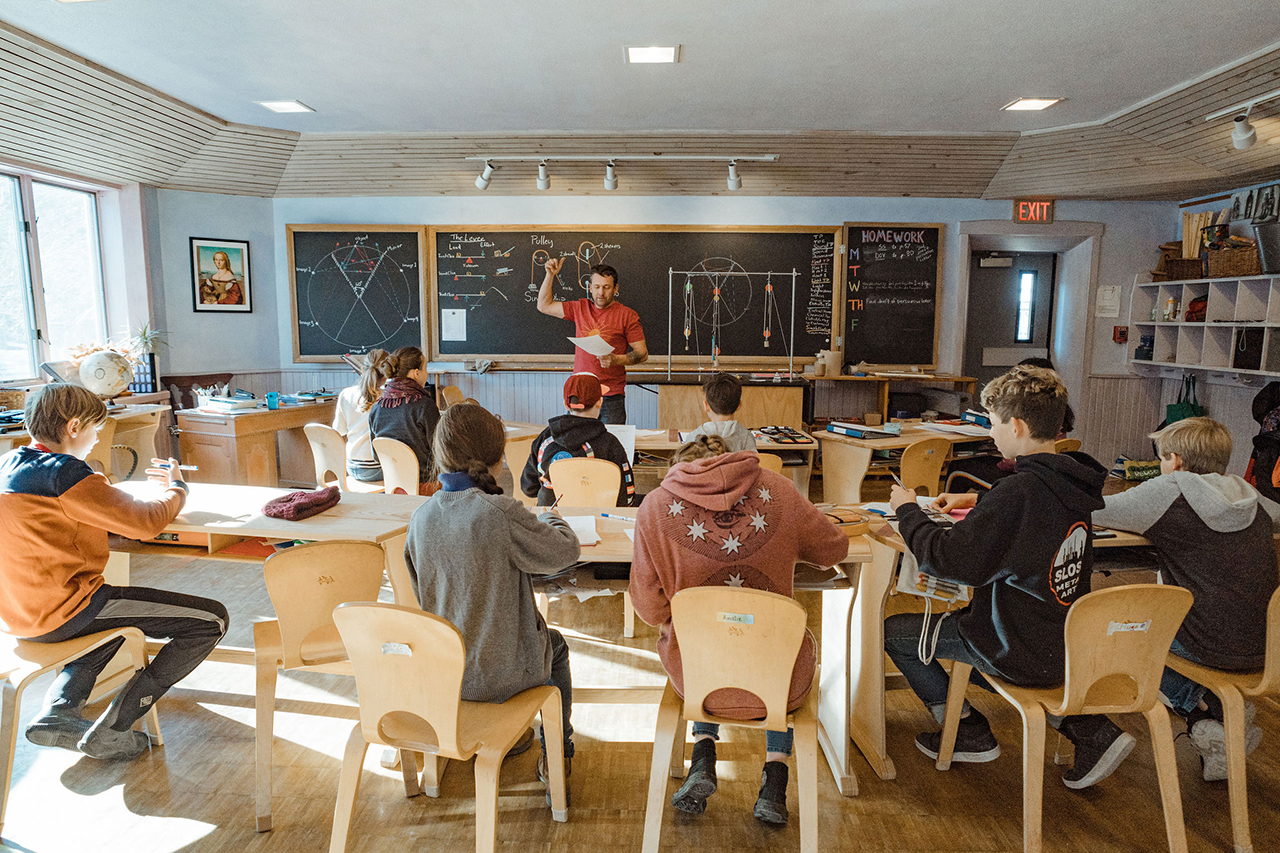 Middle School Physics block classroom view with students seated and teacher at black board