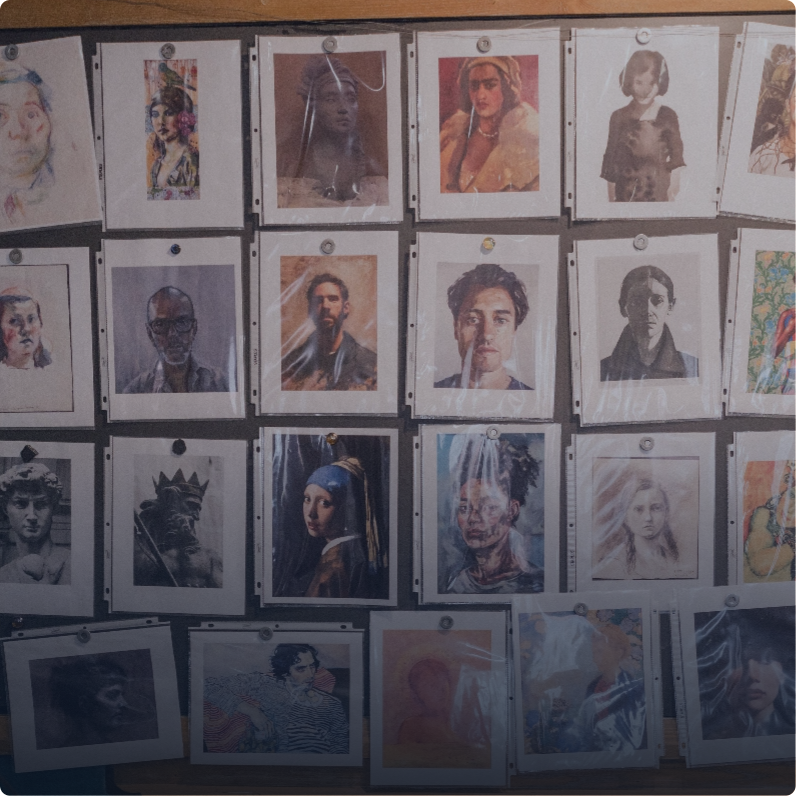 Portraits of famous people and artworks on a wall done by students.