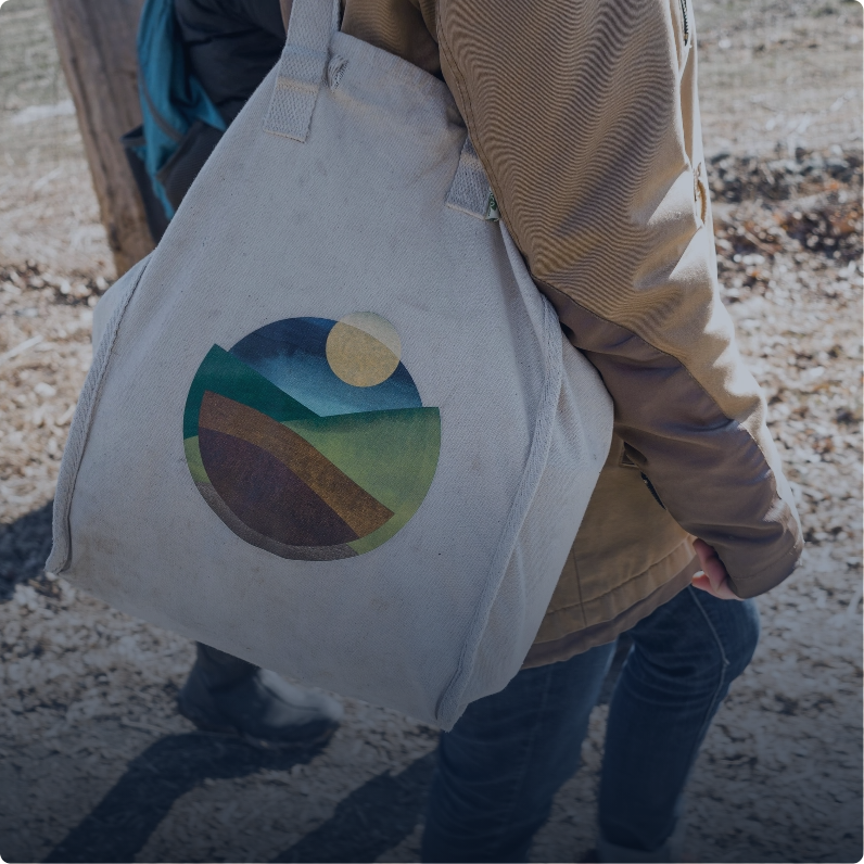 The body of a person from the side where the focus is on their Hawthorne Valley bag which has the Hawthorne Valley logo on the front.