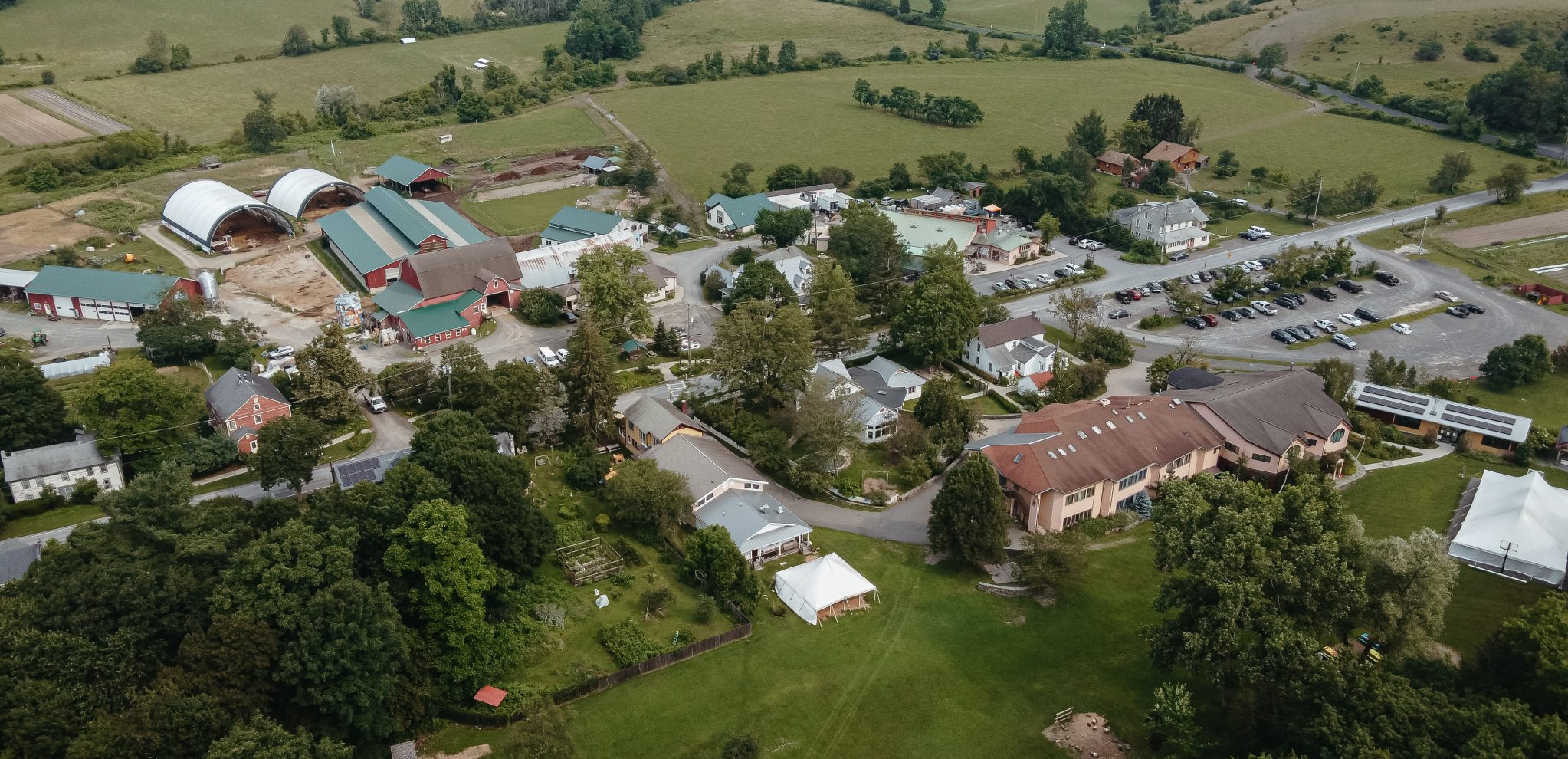 Aerial shot of campus including all buildings- school, administration, farm store, etc.- along with the farm and fields in the background.