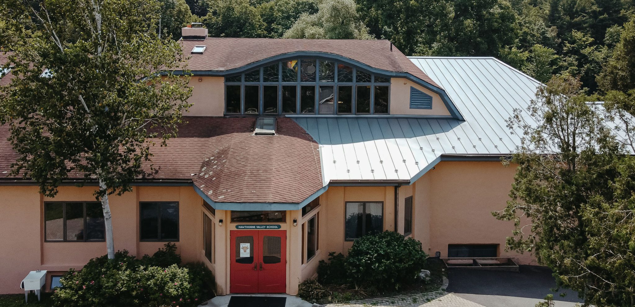 Front facing view of the middle school showing the front doors and trees behind the building.