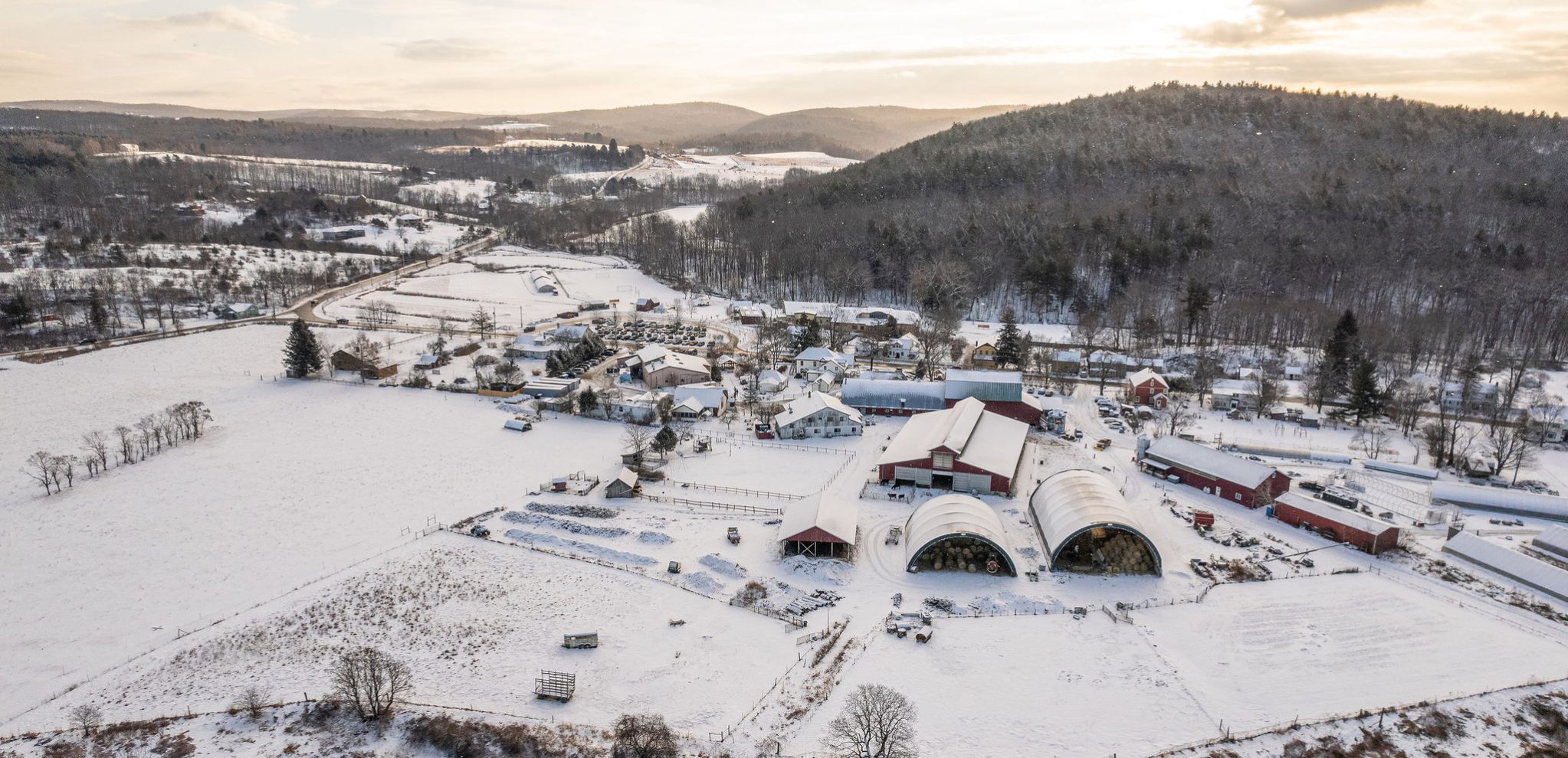 View of whole campus, including the farm buildings, in winter. It was taken during sunrise and there's a blanket of newly fallen snow