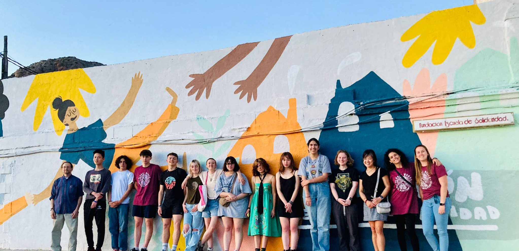 Class of 2023 stands against a colorful mural while on a trip to Spain