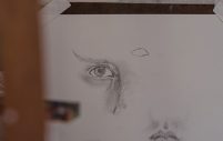 sketch of human eye and a separate sketch of human mouth on one white sheet of paper.