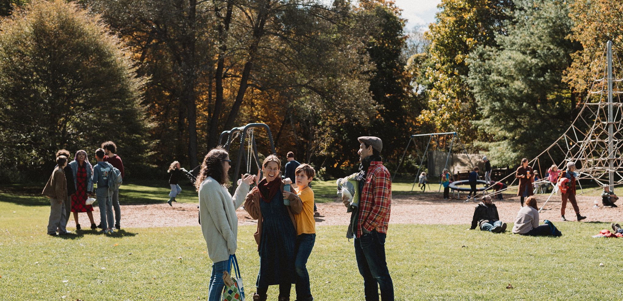 Groups of people standing together near the school playground during a recent Fall celebration